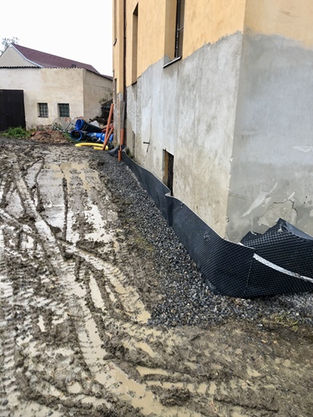 Detail drenážního systému a izolace základů bytového domu v Dívčicích
