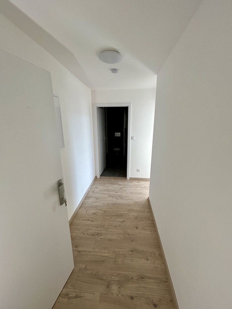 Chodba po rekonstrukci bytového domu bez podlah v obci Dívčice